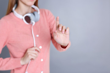 Poster - Woman hand touching virtual screen on grey background