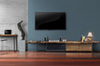 Led tv on dark blue wall with wooden table in living room