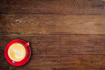 Wall Mural - red coffee cup on old wood background with space.