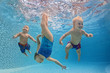 © Tropical studio - Funny photo of active babies swim and dive with fun - jump deep down underwater with splashes in swimming pool. Family lifestyle and summer children water sports activity and lessons with parents.