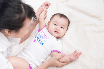 Wall Mural - Portrait of beautiful mom playing with her 6 months old baby