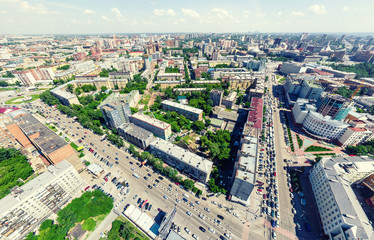 Aerial city view with crossroads and roads, houses, buildings, parks and parking lots, bridges. Urban landscape. Copter shot. Panoramic image.