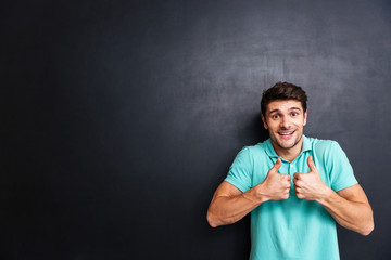 Poster - Cheerful young man showing thumbs isolated