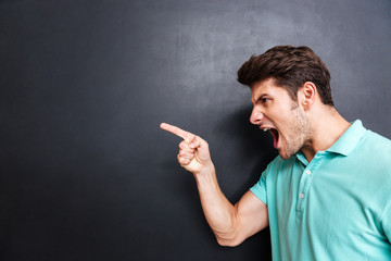 Side view of a angry man screaming over black background