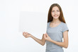 © Saksoni - Young smiling woman show blank card or paper