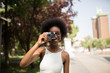 © ADDICTIVE STOCK - Afro Woman Taking Pictures in the Street