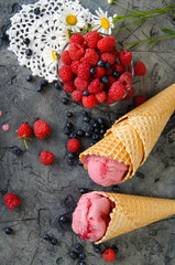 Wall Mural - Raspberry ice cream with ice cream cones on stone table.