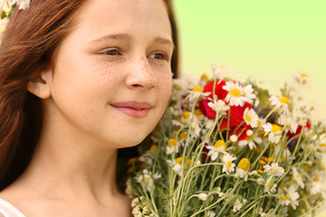 Wall Mural - Portrait of girl in meadow with wild spring flowers bouquet