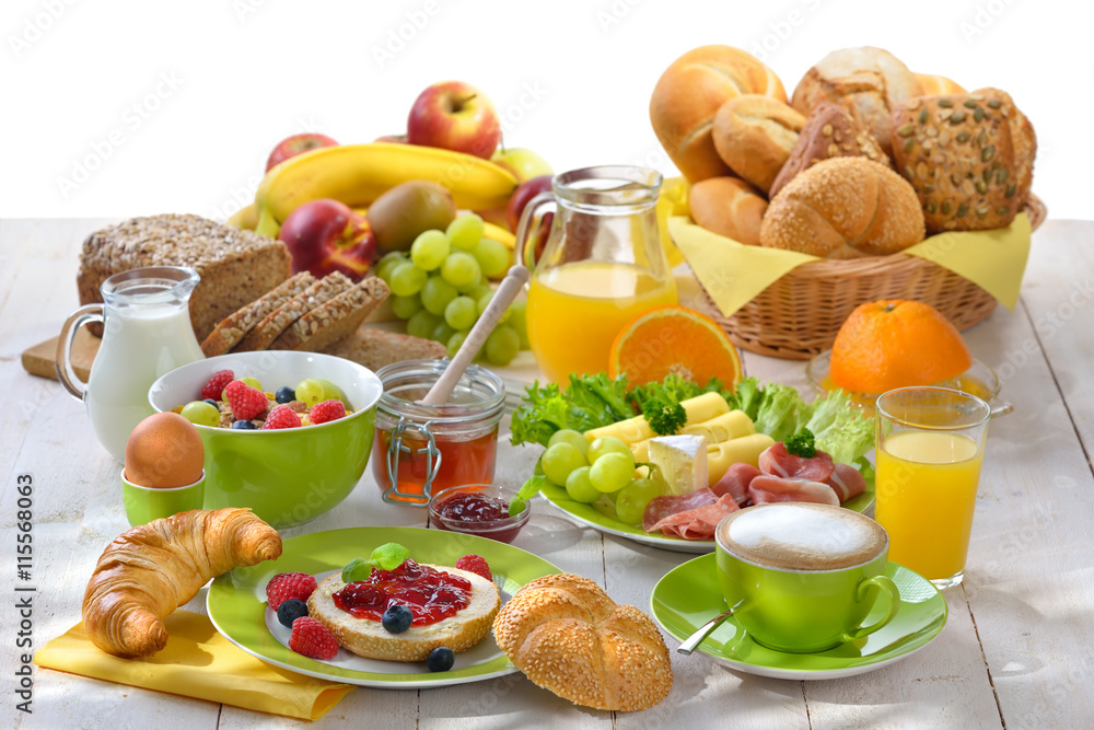 Gedeckter Frühstückstisch mit reichlicher Auswahl - Breakfast table with a cup of cappuccino and a large selection of food Stock Photo
