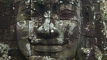 Sticker - Smiling, lichen covered, stone face of an ancient, hand carved sculpture at Bayon Temple in Angkor Thom, Cambodia. Video UltraHD