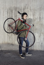 Portrait Of Man Holding Bicycle Against Wall