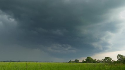 Wall Mural - timelapse with dark storm clouds are moving over countryside field, 4k