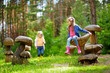 © MNStudio - Two cute little sisters having fun on giant wooden mushrooms