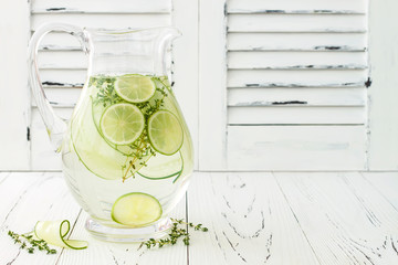 Wall Mural - Cucumber infused hydrating water with thyme and lime. Homemade flavored lemonade on rustic old wooden table