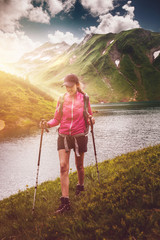 Wall Mural - active fit woman hiking alongside an alpine lake