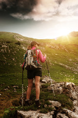 Wall Mural - woman trekking in the alps with a backpack