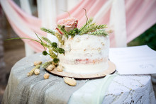 Wedding Cake With Rose And Peanuts In Old Style On Table