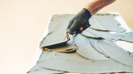 Wall Mural - man working with trowel and foam plastic at home renovation