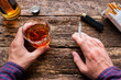man holding a glass of whiskey and smoking a cigarette