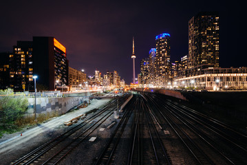 View of a rail yard and modern buildings in downtown at night, f