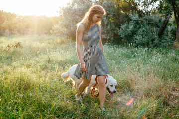 Wall Mural - girl playing with labrador retriever dog in park