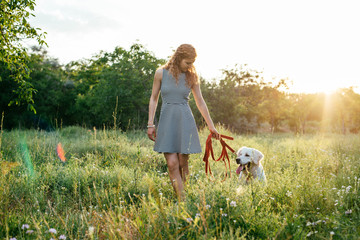 Wall Mural - girl playing with labrador retriever dog in park