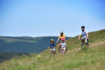 Wall Mural - Family of four riding bikes in the mountain