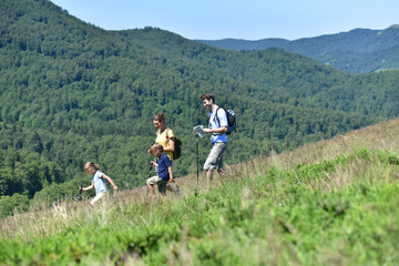 Wall Mural - Family of four hiking in the mountain