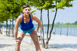 © Wisiel - Fit jogger woman resting after run in city park.