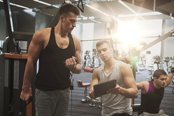 Canvas Print - men exercising on gym machine