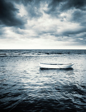 White Wooden Fishing Boat Under Stormy Clouds