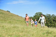 © goodluz - Family on vacation running down the hill