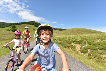 Wall Mural - Portrait of little boy riding bike with family