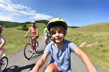 Wall Mural - Portrait of little boy riding bike with family