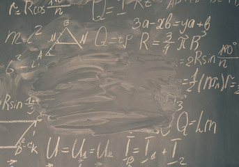 math formulas written in white chalk and copy space on black board, retro toned