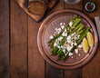 Warm salad of roasted asparagus, feta cheese, nuts, flavored with lemon juice. Top view