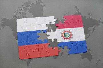 puzzle with the national flag of russia and paraguay on a world map background.