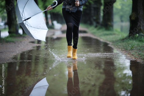 Fotografía feet in rubber boots rain puddle city