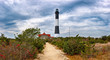 Fire Island Lighthouse with stormy skies and colors of  fall foliage  The lighthouse is located on the Great South Bay, southern coast of Long Island, New York