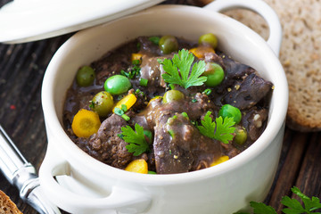 Wall Mural - Chicken liver in  sauce with vegetable on wooden background