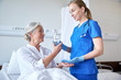 © Syda Productions - nurse giving medicine to senior woman at hospital