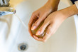 Woman with long fingers and nails washing hands with hypoallergenic soap at home