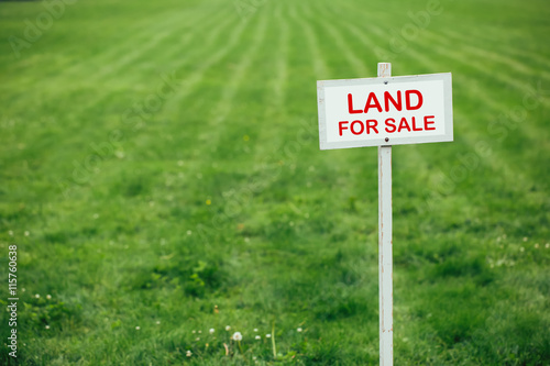 Fotografía land for sale sign against trimmed lawn background