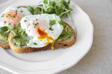 poached eggs with avocado and sunflower sprout on sourdough toas