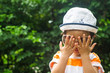 © pummy - Cute toddler boy wearing sunglasses playing hide and seek  in the park