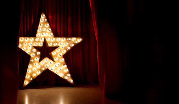 Fototapete - Photo of golden star with light bulbs on red velvet curtain on stage