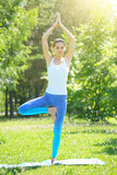 Fototapeta Las - Pretty woman doing yoga exercises