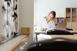 © Astrakan Images - Young woman writing at desk in classroom