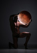 © kazanovskyiphoto - Young naked man with muscular body stands kneeling on floor