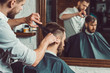 © master1305 - Young handsome barber making haircut of attractive man in barbershop